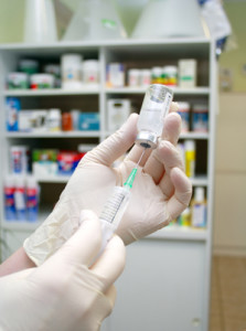 person filling a syringe with vaccine